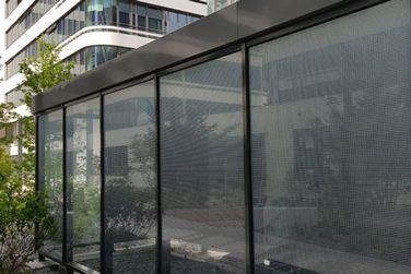 Ein Gebäude mit vielen Fenstern und Bäumen davor.