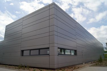 Ein großes Gebäude mit vielen Fenstern an den Seiten.