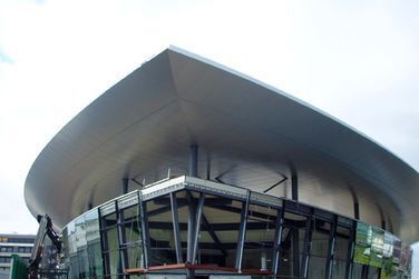 Ein großes Gebäude mit einem geschwungenen Dach und vielen Fenstern