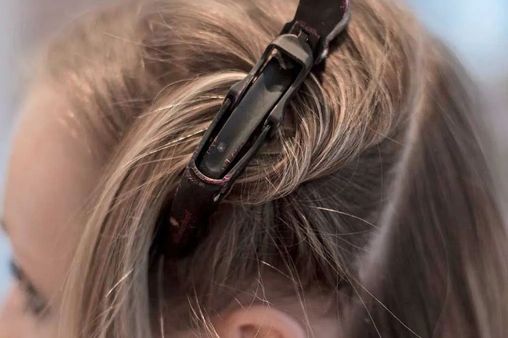 Haare einer Kundin in einer Haarklammer fixiert