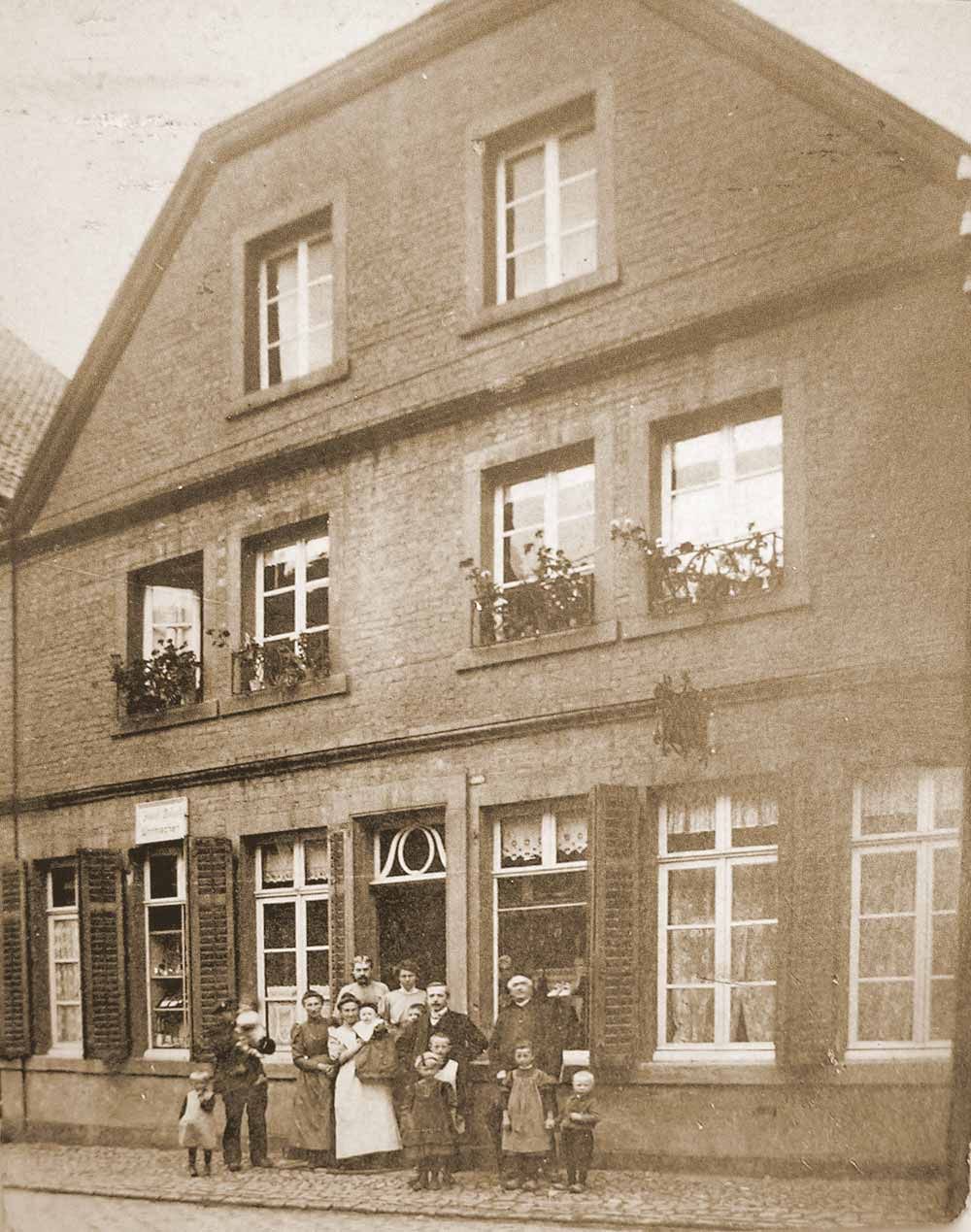 Eine Gruppe von Menschen steht vor einem großen Backsteingebäude