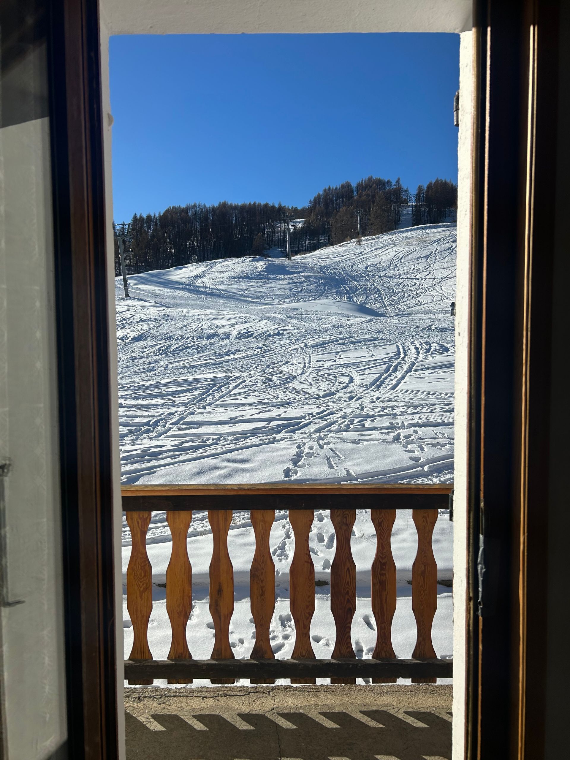 Une enseigne portant l'inscription Le Belvédère sur une porte en bois d'un bâtiment rustique.