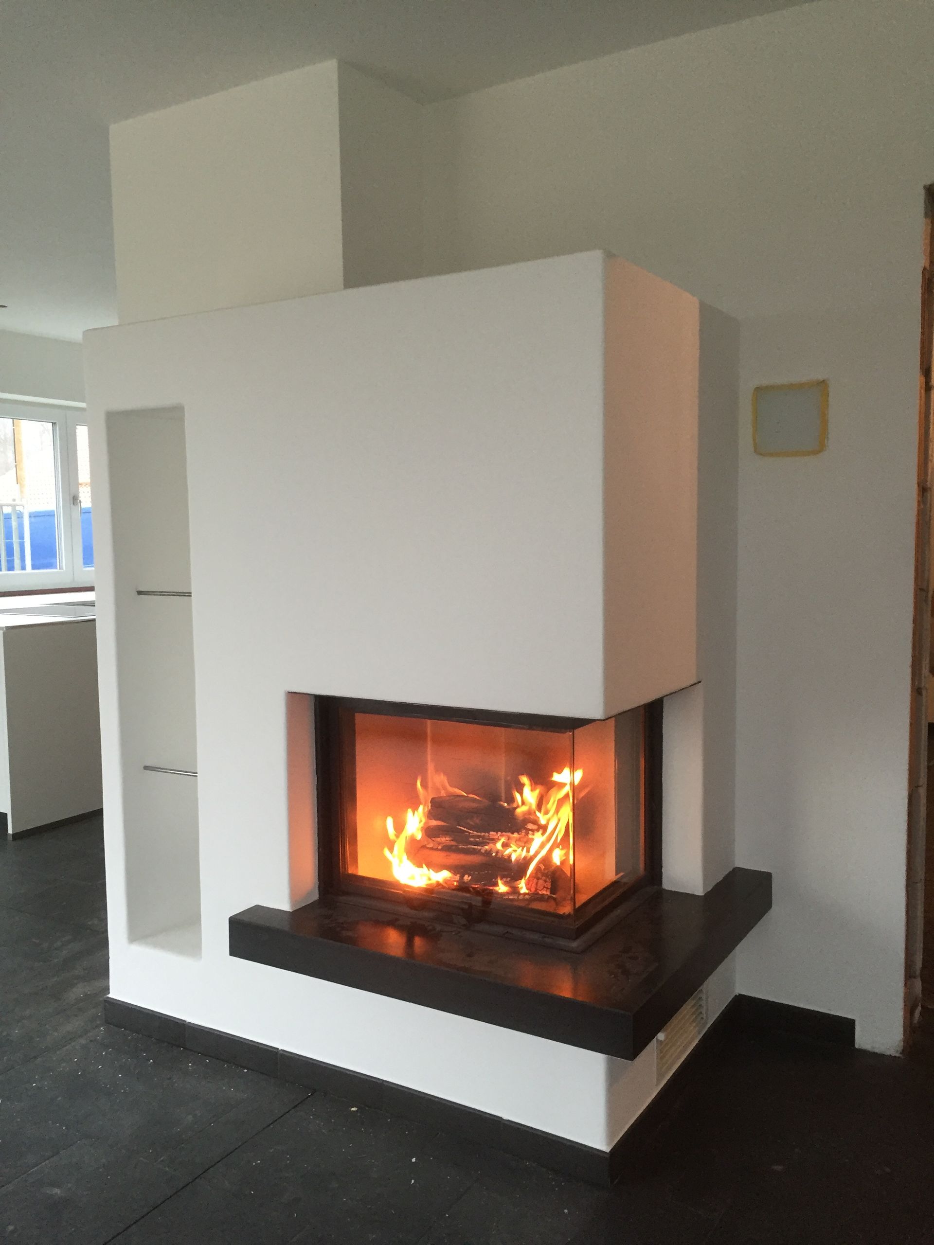 Moderner weißer Kamin mit brennendem Feuer in einem minimalistischen Wohnzimmer