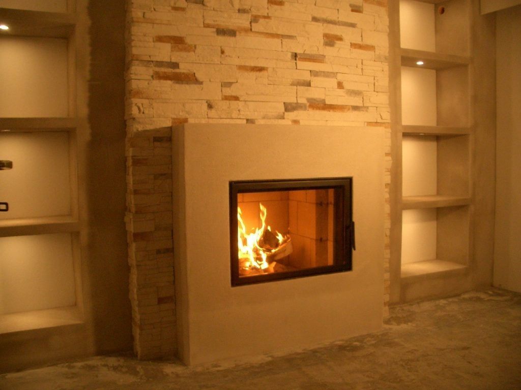 Moderner Kamin, eingelassen in eine beige Steinwand mit integrierten Regalen auf beiden Seiten.