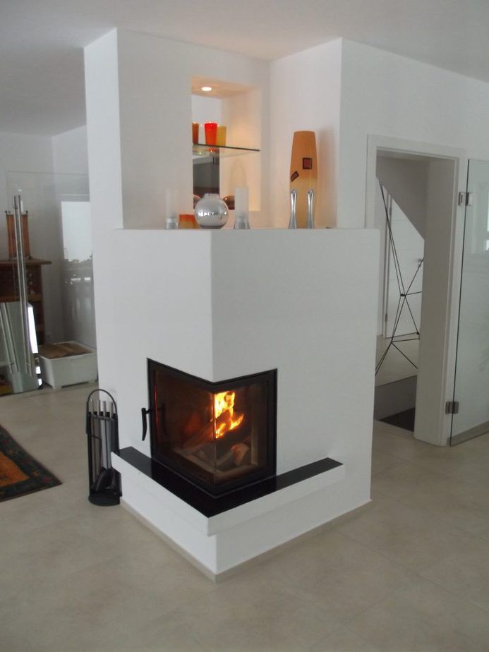 Modernes weißes Wohnzimmer mit brennendem Kamin, eingebautem Regal.