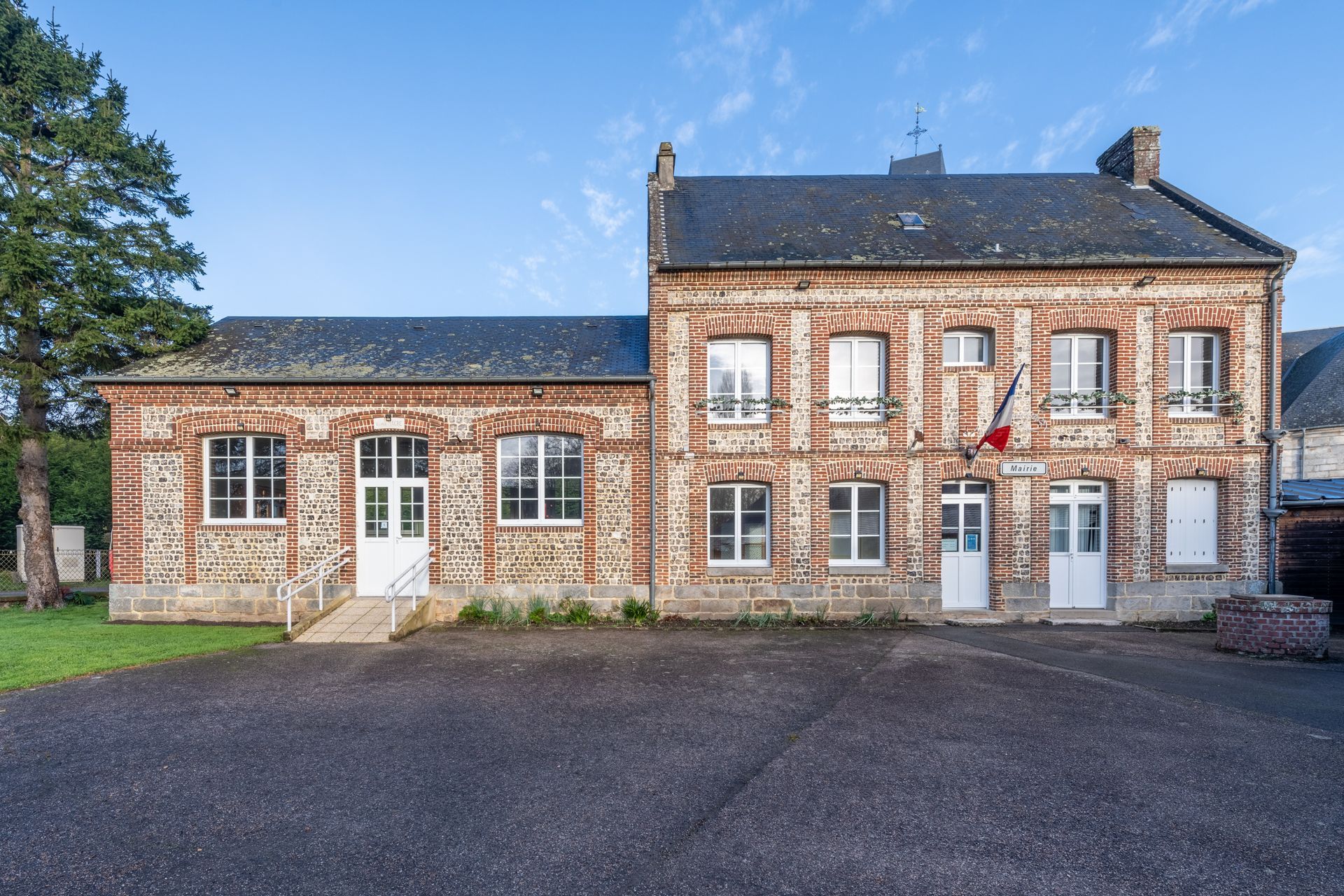 Une grande maison en pierre avec un pavage devant