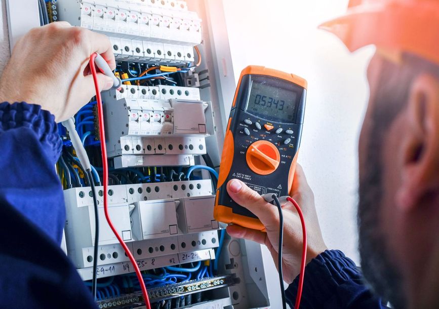 Un électricien règle un tableau électrique