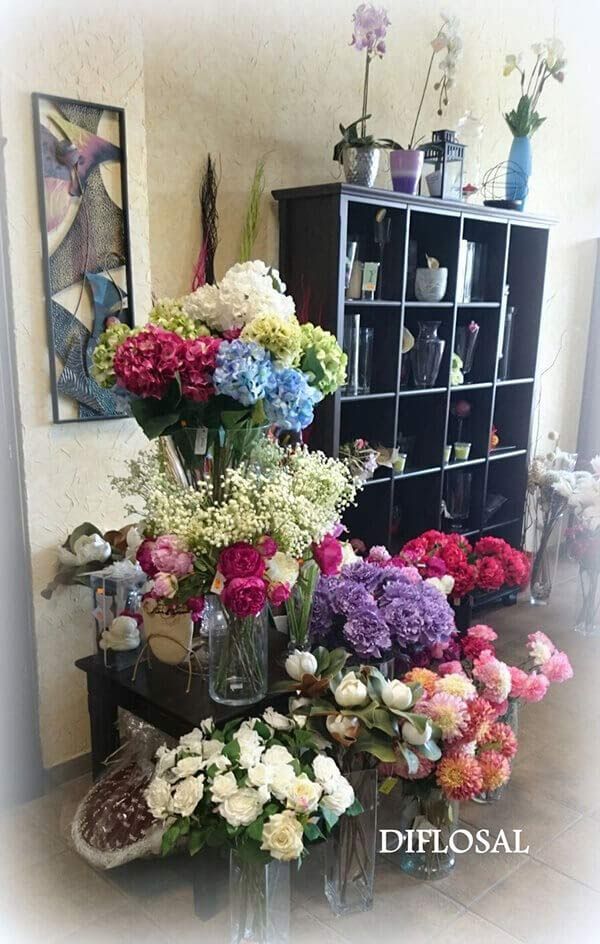 Exhibición de floristería colorida con ramos y orquídeas.