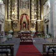 Interior de la iglesia de La Clerecía: altar dorado, alfombra roja, flores blancas y decoraciones ornamentadas.