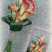 Ramo de calas naranjas con vegetación, tallos envueltos en arpillera y un pequeño arreglo floral.