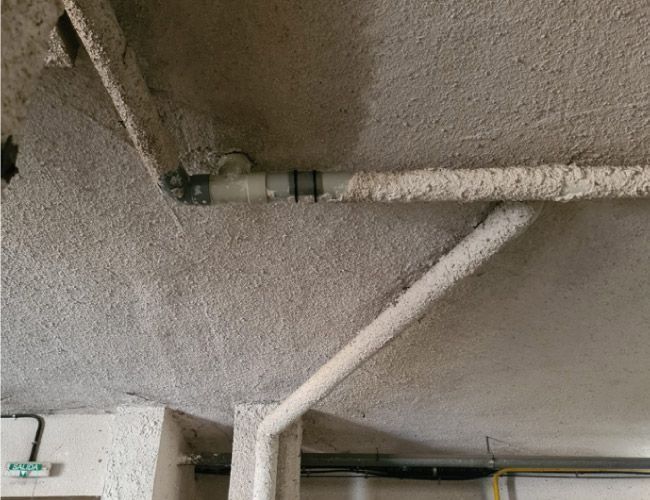 Una tubería cuelga del techo de un edificio.