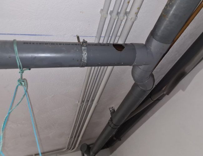 Un montón de tubos cuelgan del techo de una habitación.