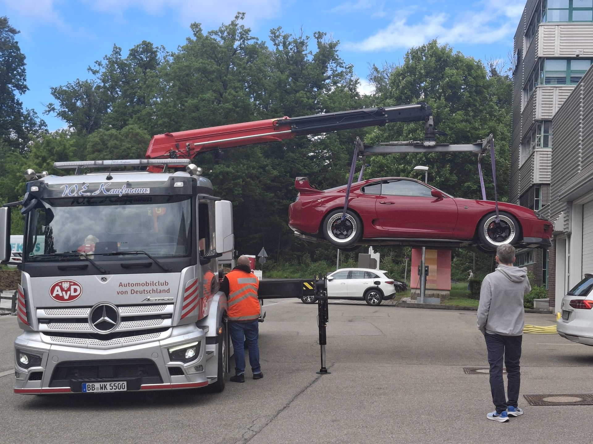 Ein rotes Auto wird von einem Mercedes-LKW angehoben