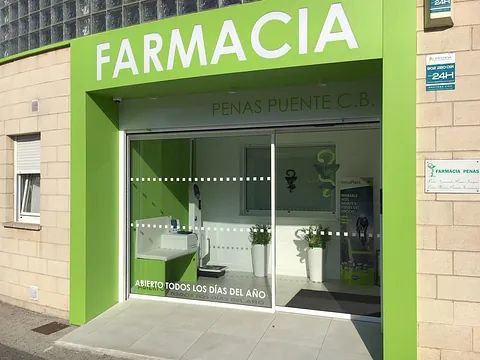 Una farmacia verde y blanca con una puerta corrediza de vidrio.