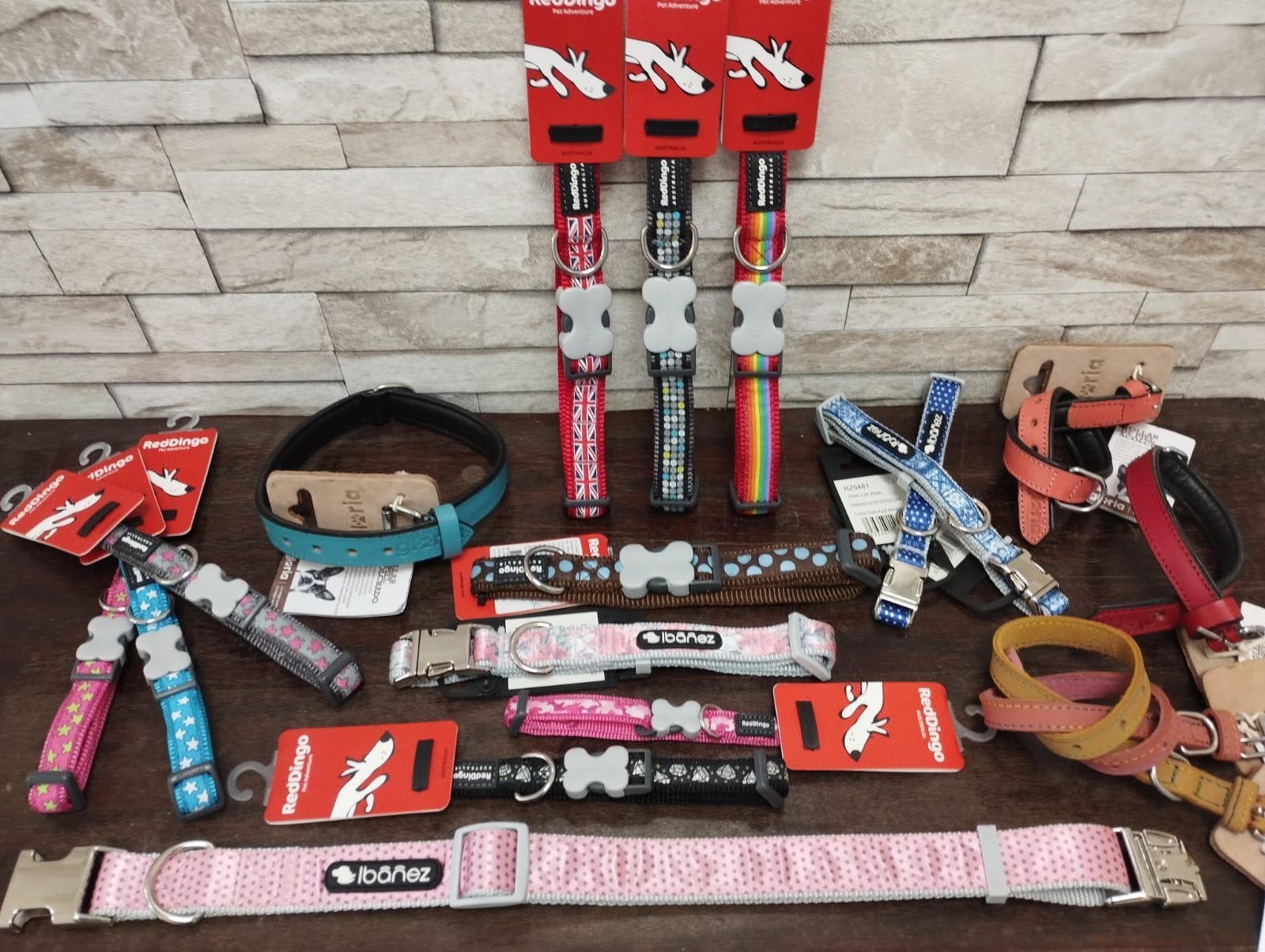 Un montón de collares y correas para perros sobre una mesa.