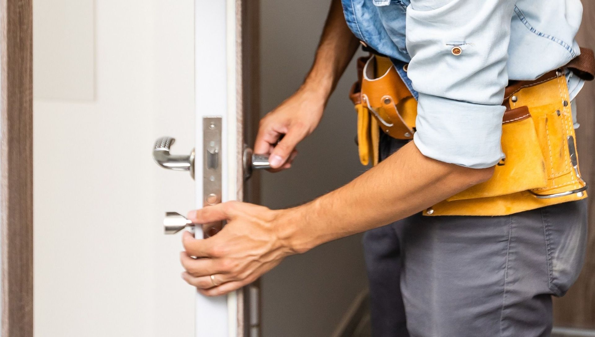 Un hombre está arreglando una manija de puerta.