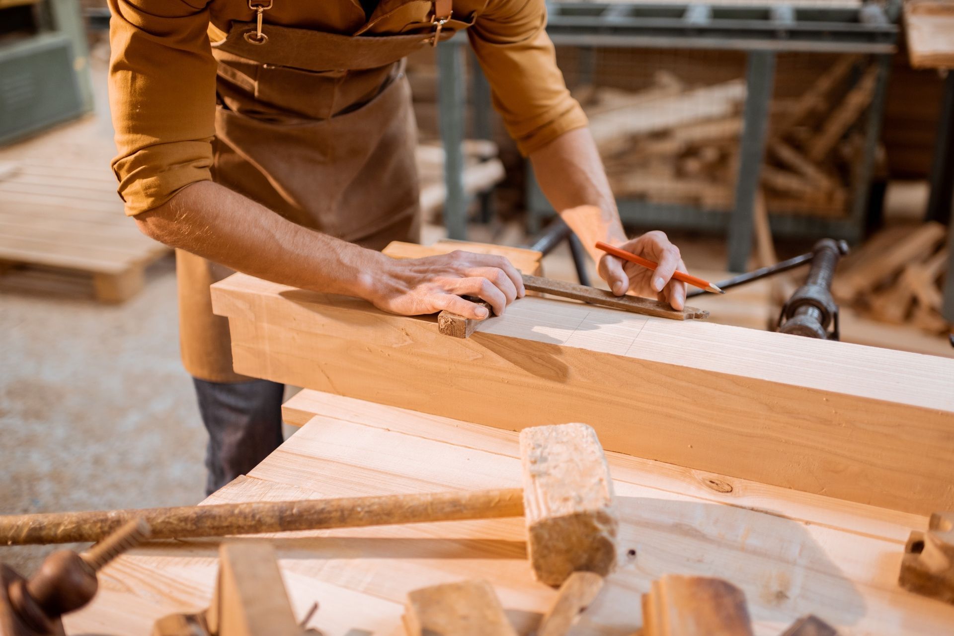 Un hombre está trabajando en un trozo de madera en un taller.