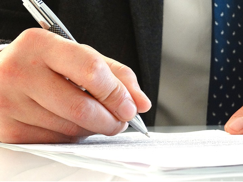 Main tenant un stylo pour remplir un contrat