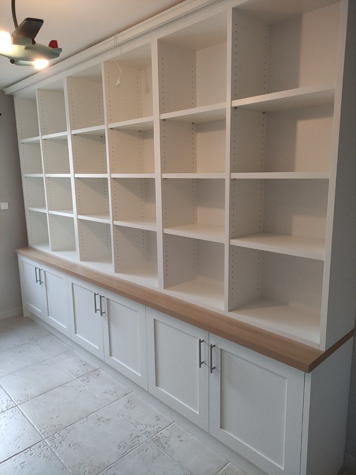 Étagère encastrée blanche avec placards, posée sur un comptoir en bois.