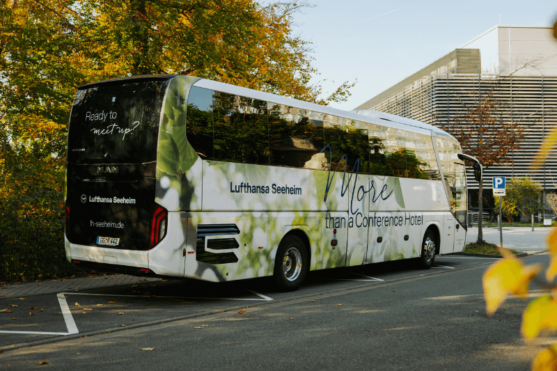 Ein weiß-grüner Bus steht auf einem Parkplatz.