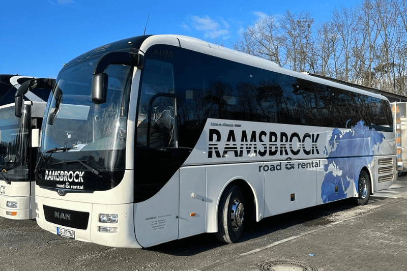 Ein weißer Bus mit dem Wort „Ramsbrock“ an der Seite steht auf einem Parkplatz.