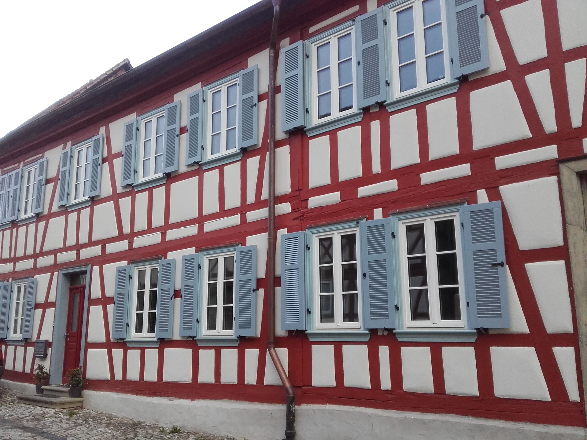 Beigefarbenes Gebäude im klassischen Stil mit Bogenfenstern und einem zentralen Eingang.