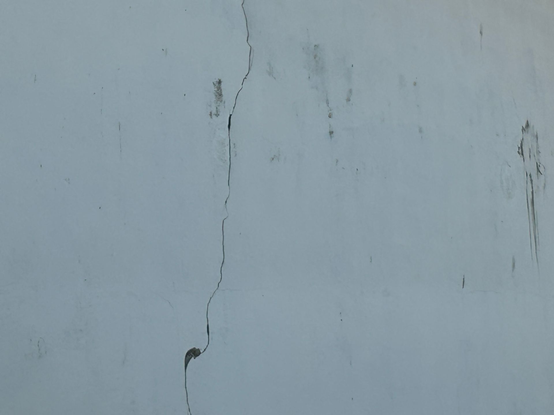 Mur blanc fissuré avec de légères taches.