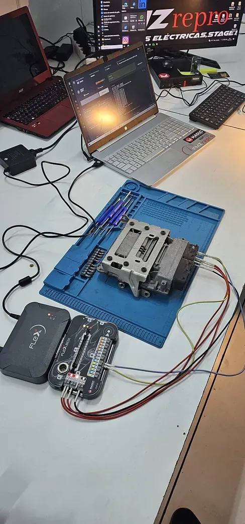 Una computadora portátil está sobre una alfombra azul en una mesa.