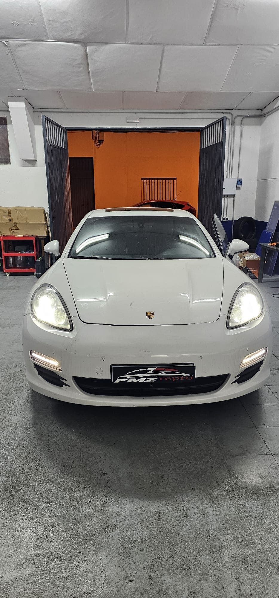 Un Porsche Panamera blanco está aparcado en un garaje.