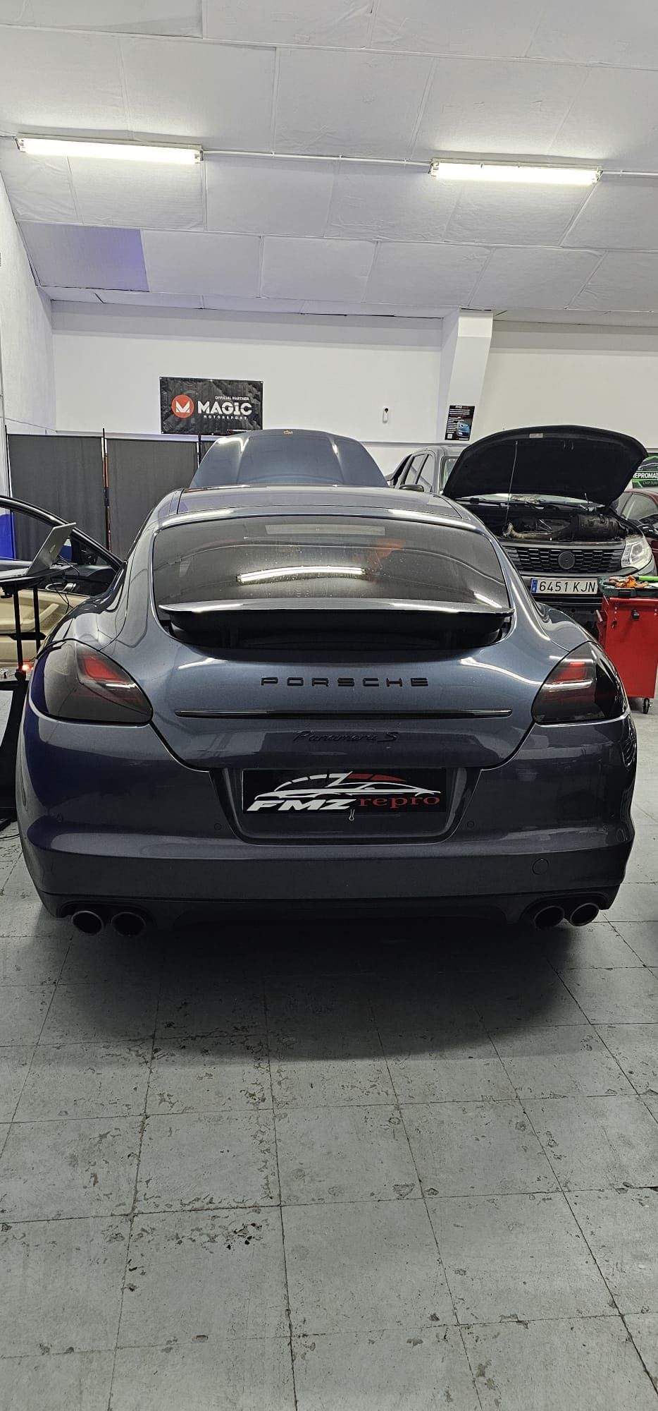 Un Porsche Panamera azul está aparcado en un garaje.