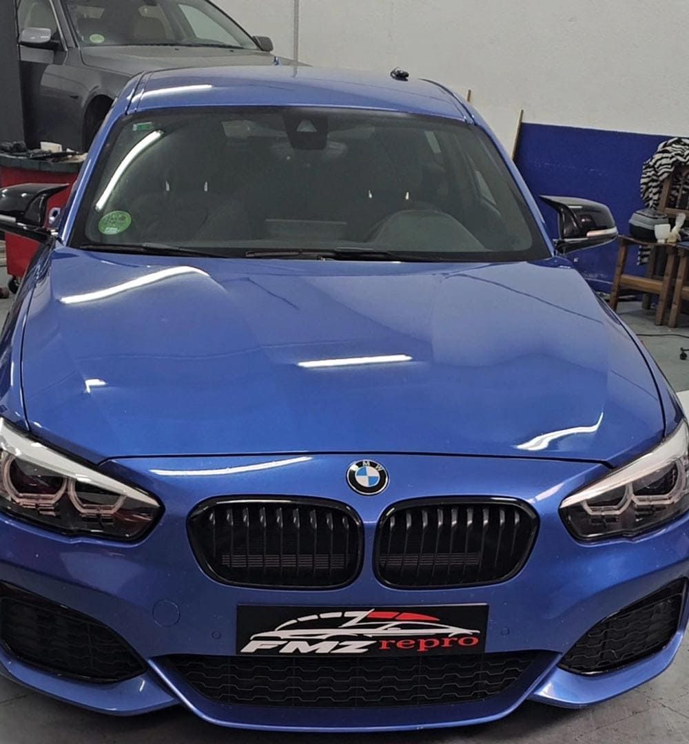 Un BMW azul está aparcado en un garaje.