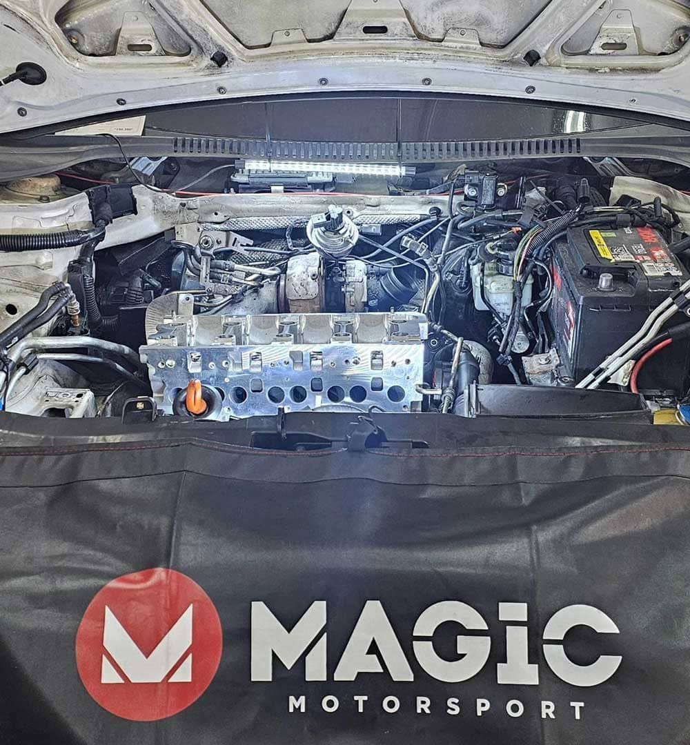 El motor de un coche está siendo trabajado por magic motorsport.
