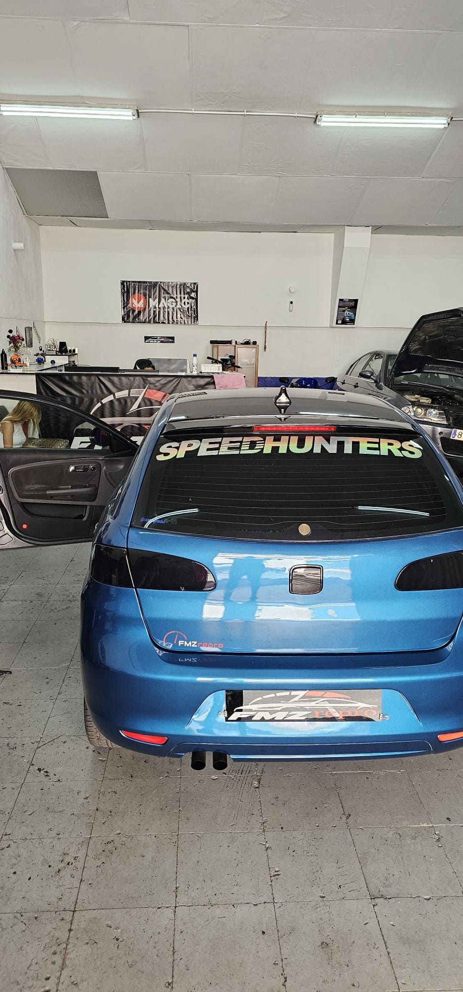 Un coche azul está aparcado en un garaje.