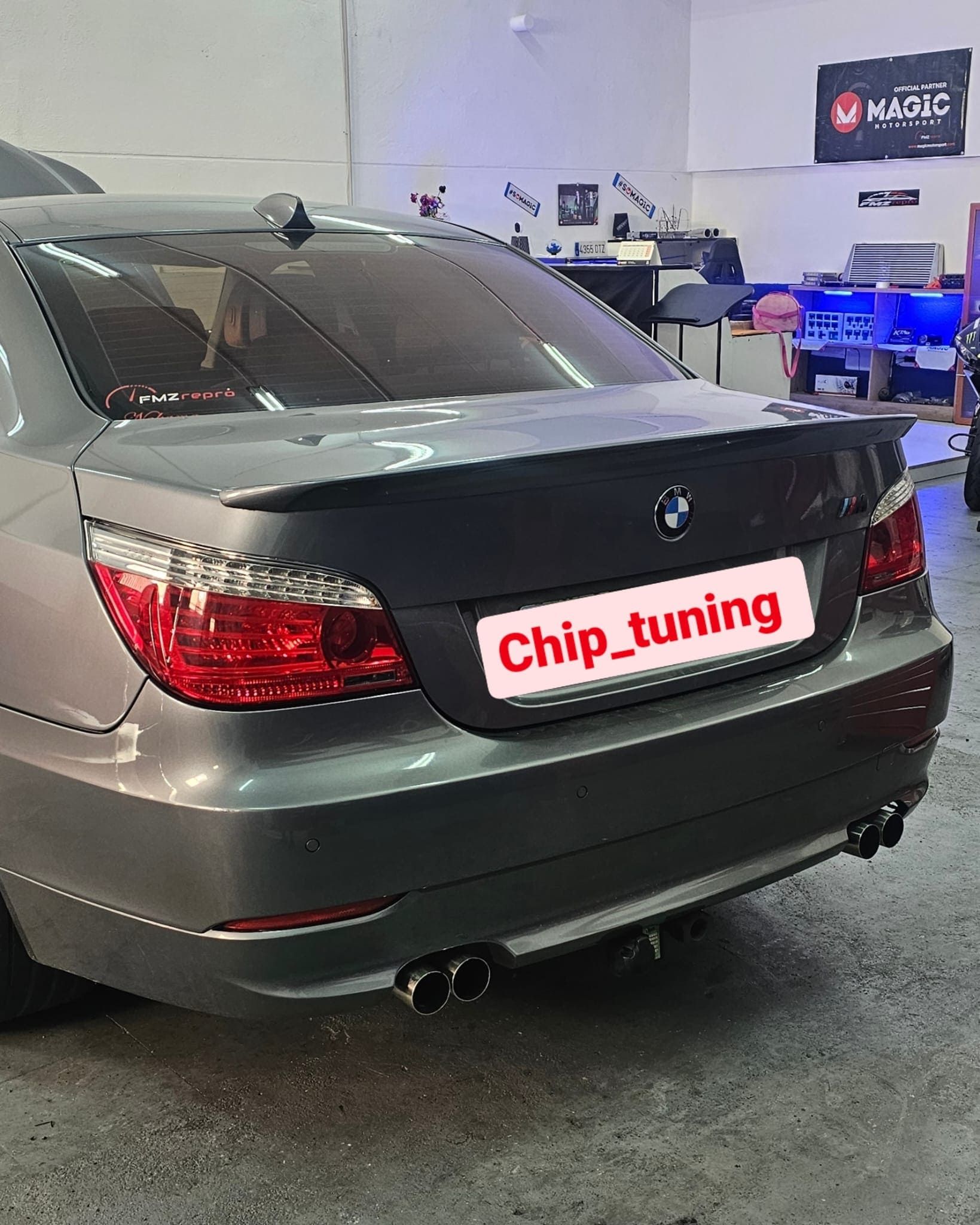 Un coche gris con un cartel de chip tuning en la parte trasera.