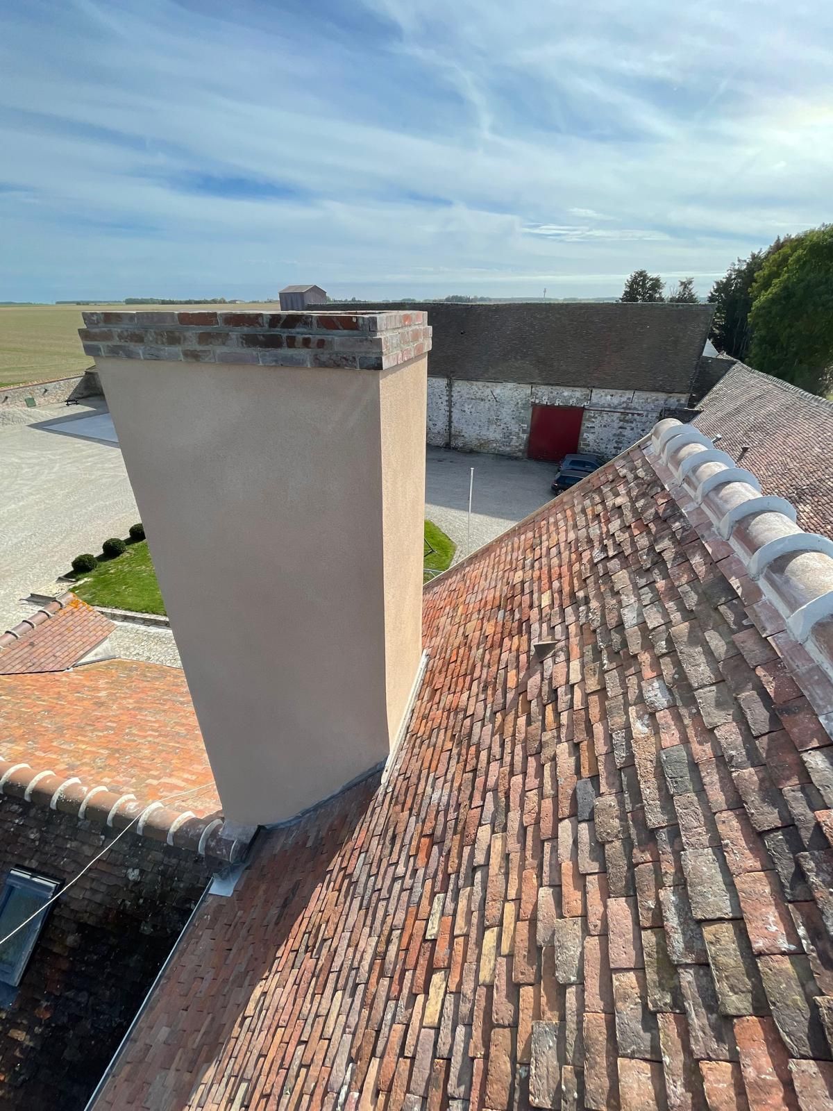 Toiture en tuiles de terre cuite empilées aux tons gris et orangés patinés