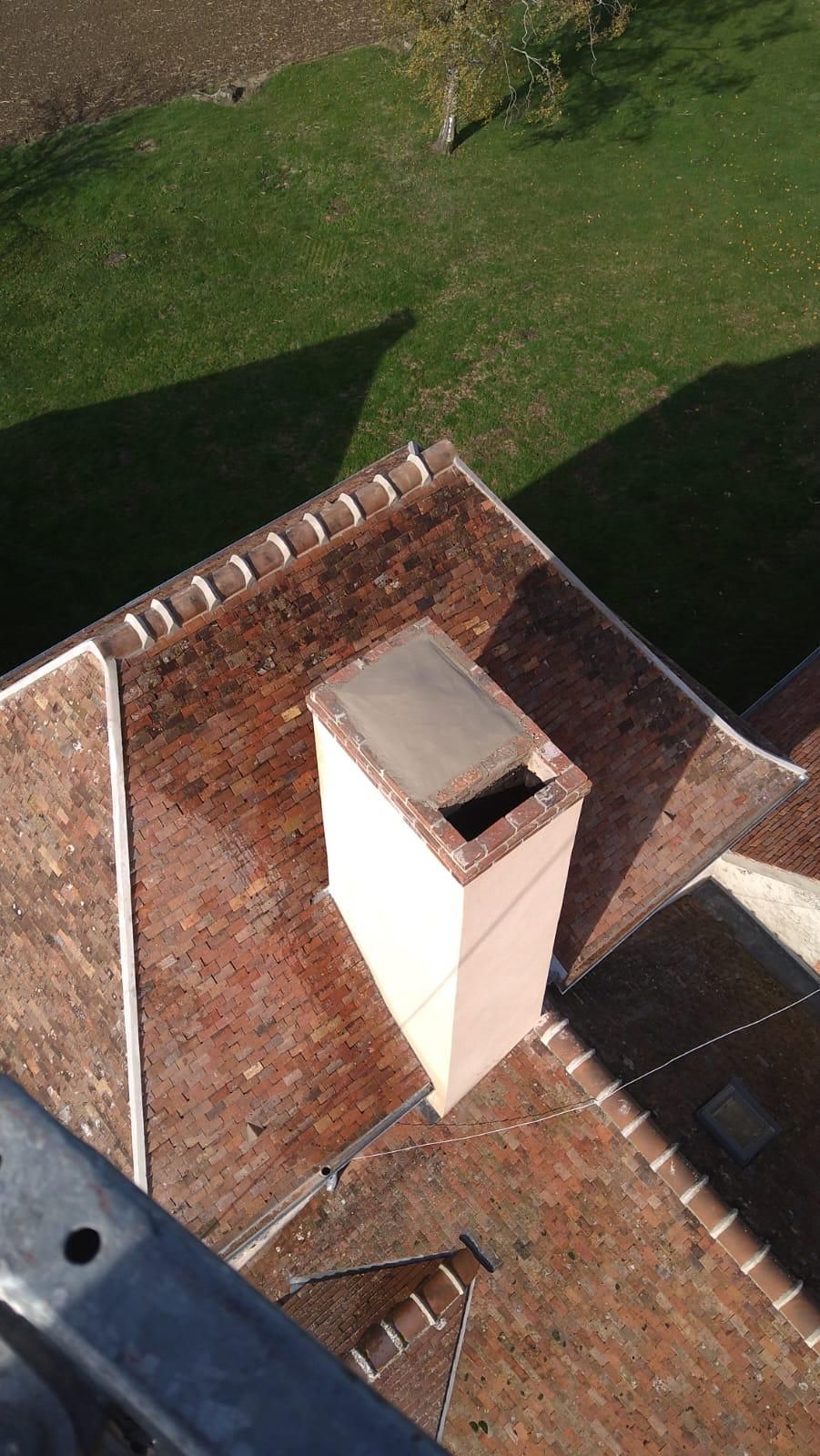 Des ouvriers installent des tuiles orange sur le toit d'une maison.