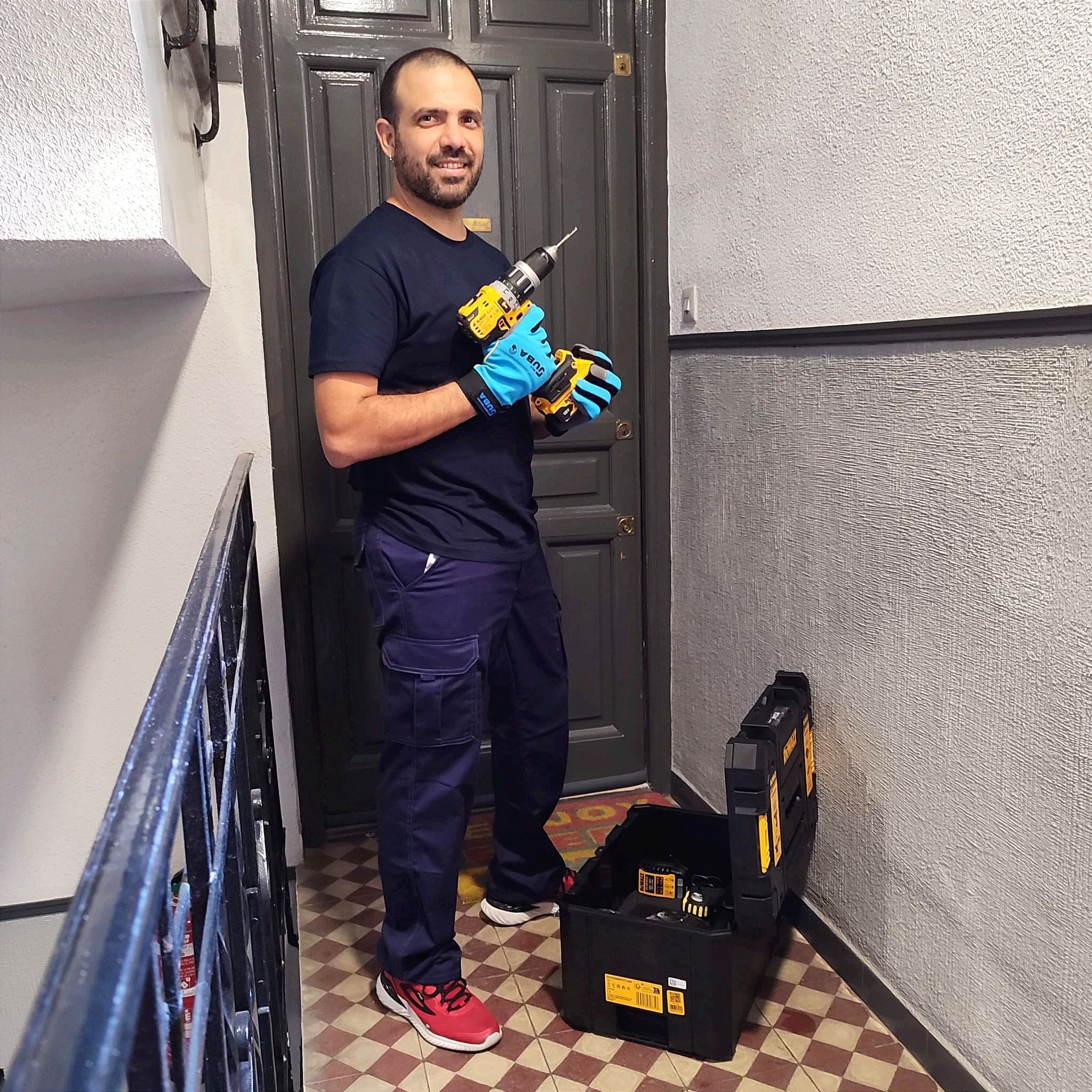 Persona con cinturón de herramientas instalando una manija en una puerta blanca.