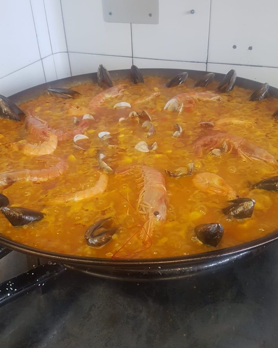 Gran sartén de paella con camarones, mejillones y arroz.