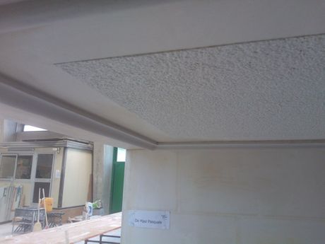 Una stanza con il soffitto bianco e un cartello sul muro che dice normale.