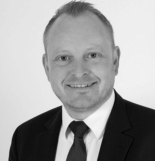 Zwei Männer laden Kisten in einen Lieferwagen.