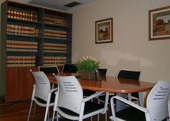 Una sala de conferencias con una mesa, sillas y estanterías.