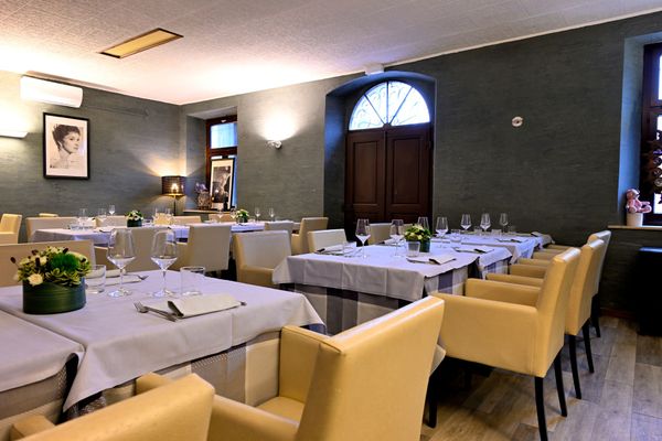 Una sala da pranzo con tavoli e sedie e un quadro sul muro - Osteria Teatro Unione L'Entrecôte 