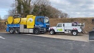 Un camion d'assainissement aux couleurs de la société et un véhicule léger d'intervention.