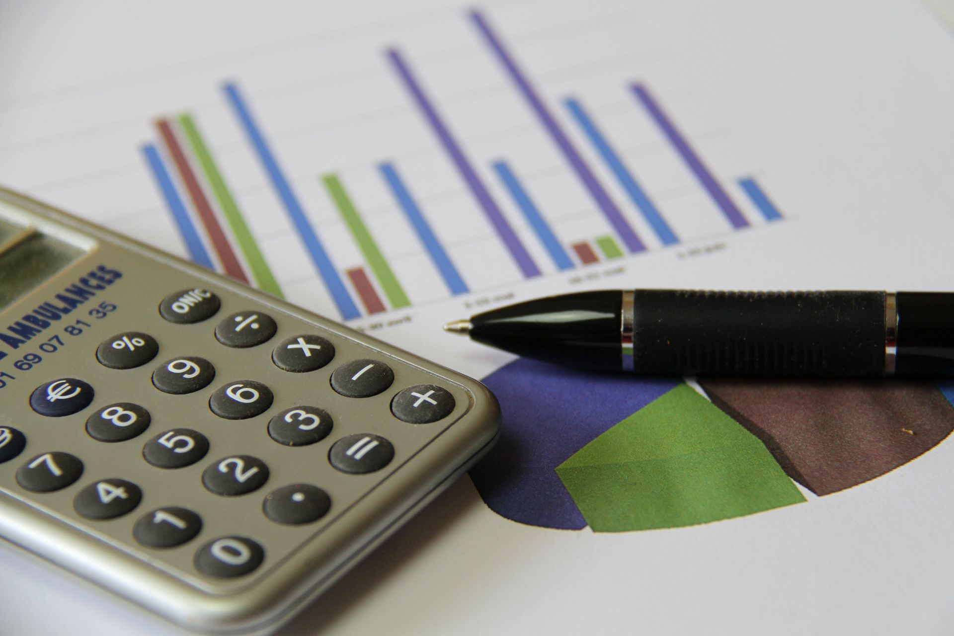 Une calculatrice et un stylo sur des représentations graphiques.