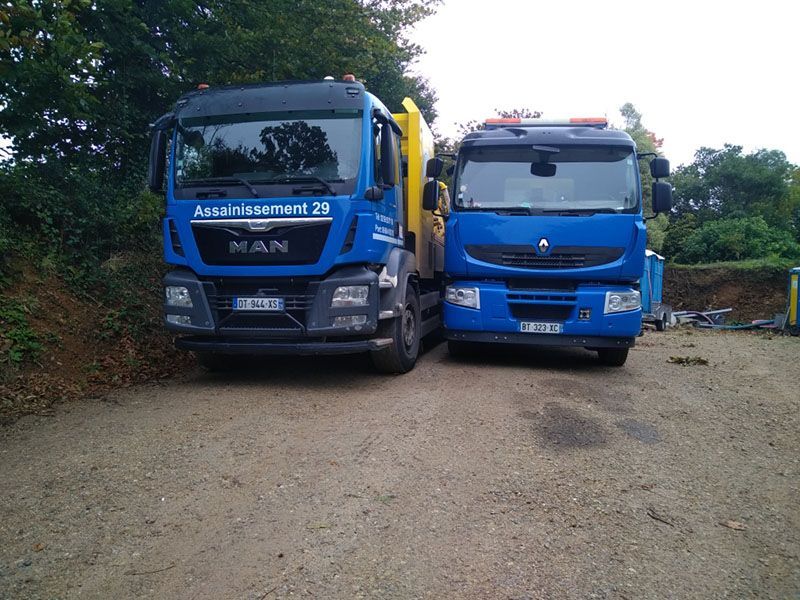 Deux camions d'assainissement estampillés aux couleurs de l'entreprise Assainissement 29.