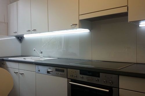 Eine Küche mit Geräten aus Edelstahl und weißen Schränken