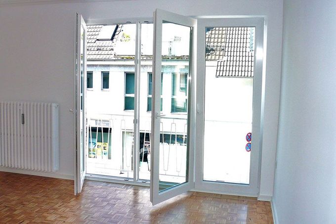 Ein leerer Raum mit Balkon und Glasschiebetüren