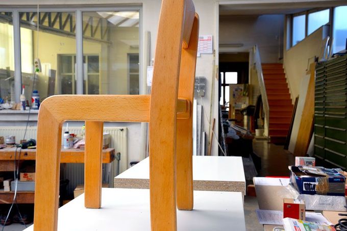 Ein Holzstuhl steht auf einem Tisch in einer Werkstatt