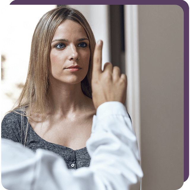 Mujer frente a un médico, siguiendo un dedo con la mirada. Interior.