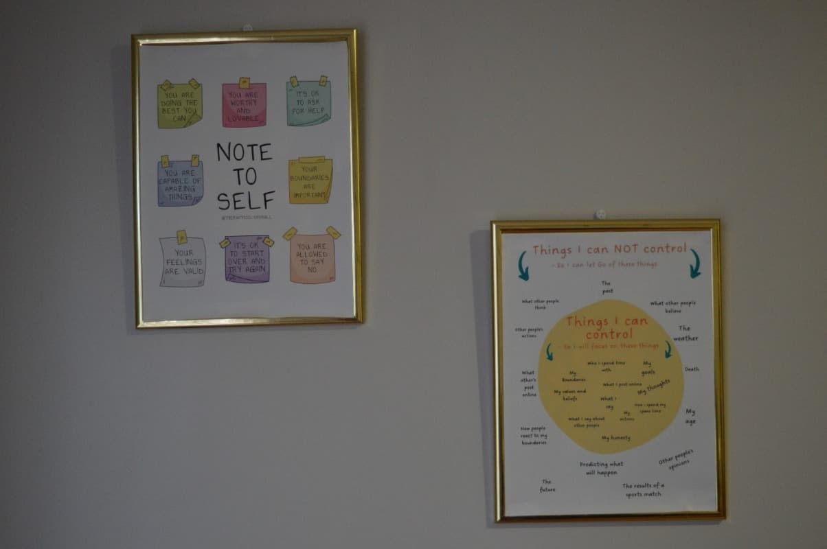 Dos carteles enmarcados en una pared, uno de los cuales dice nota para mí